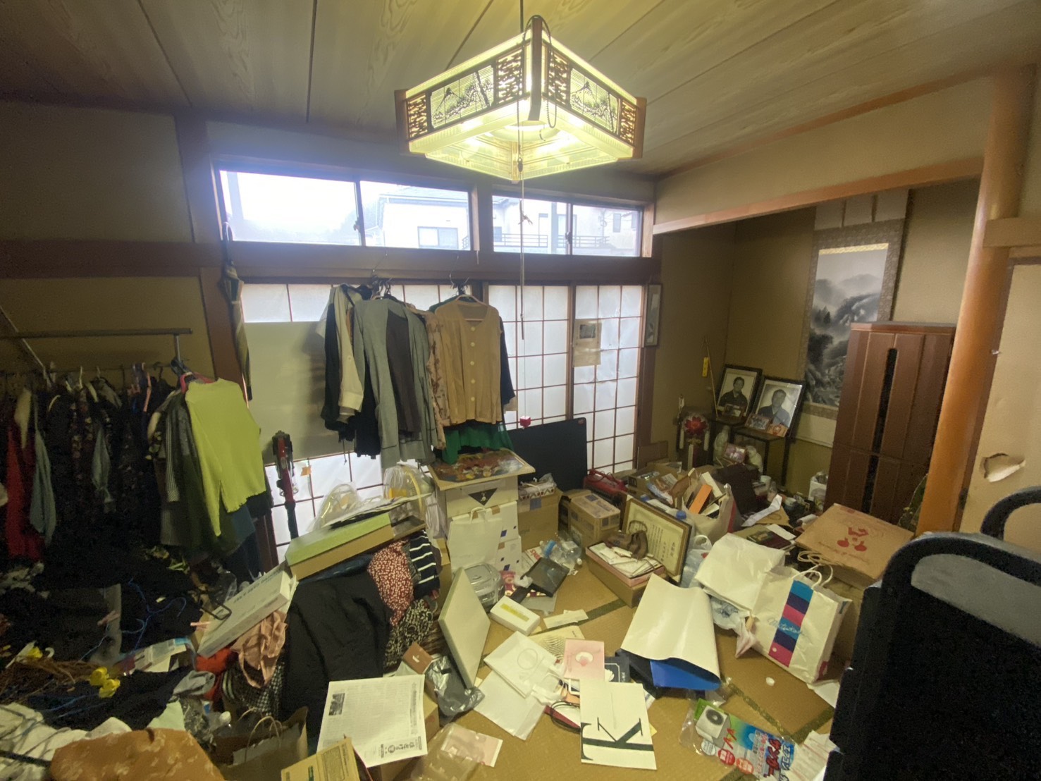 衣類や書類が散乱した和室